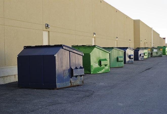 a fleet of red and blue construction dumpsters available for use in Alex